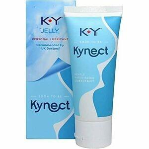 A tube of KY Jelly Personal Lubricant stands upright on a neutral background, clearly displaying the brand logo and product name. The packaging highlights its use as a personal lubricant, emphasizing its safety, compatibility with condoms, and ease of use for enhancing comfort and intimacy. The setting is simple and discreet, focusing attention on the product's key features