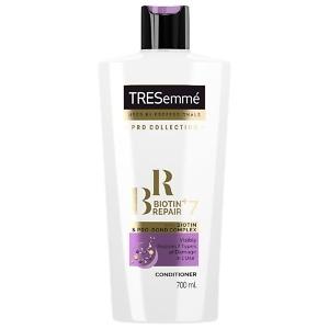 A 700ml bottle of TRESemmé Biotin Repair 7 Conditioner with a sleek white and purple design. The bottle features the TRESemmé logo and highlights its biotin-infused formula, designed to repair damaged, brittle, and weak hair. The label emphasizes its ability to strengthen, protect, and restore hair affected by heat, styling, coloring, and environmental damage, making it ideal for dry and damaged hair types.